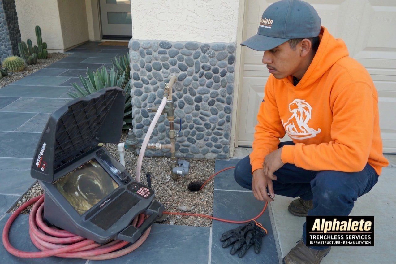 Alphalete Trenchless technician running a sewer camera inspection